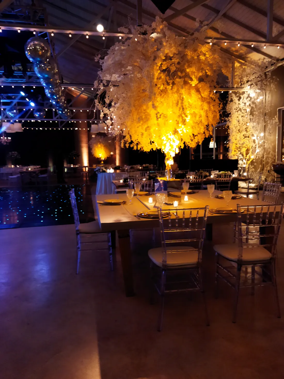 Mesas de madera con un árbol iluminado en el salón