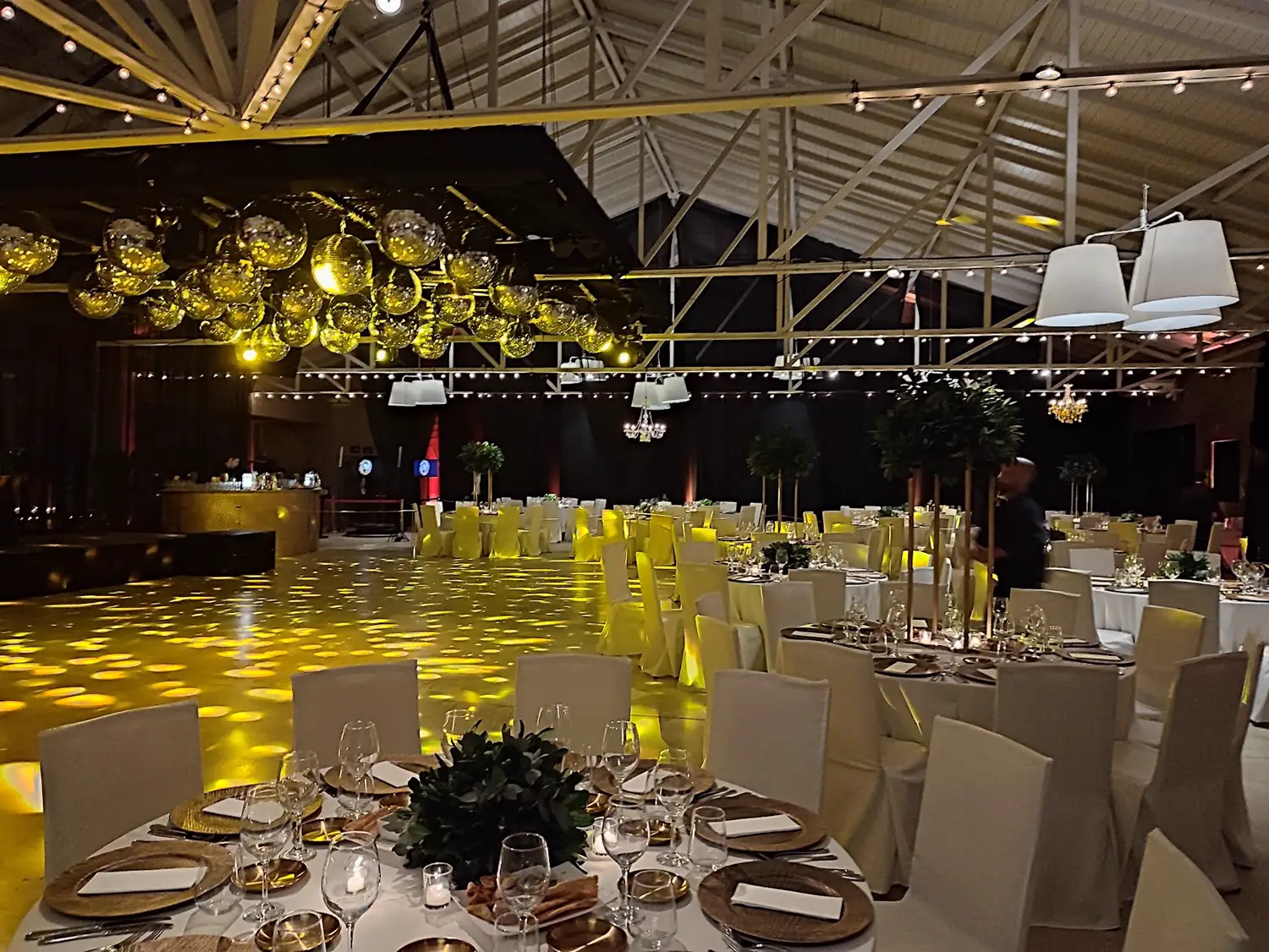 Salón con el techo de esferas doradas y las mesas armadas